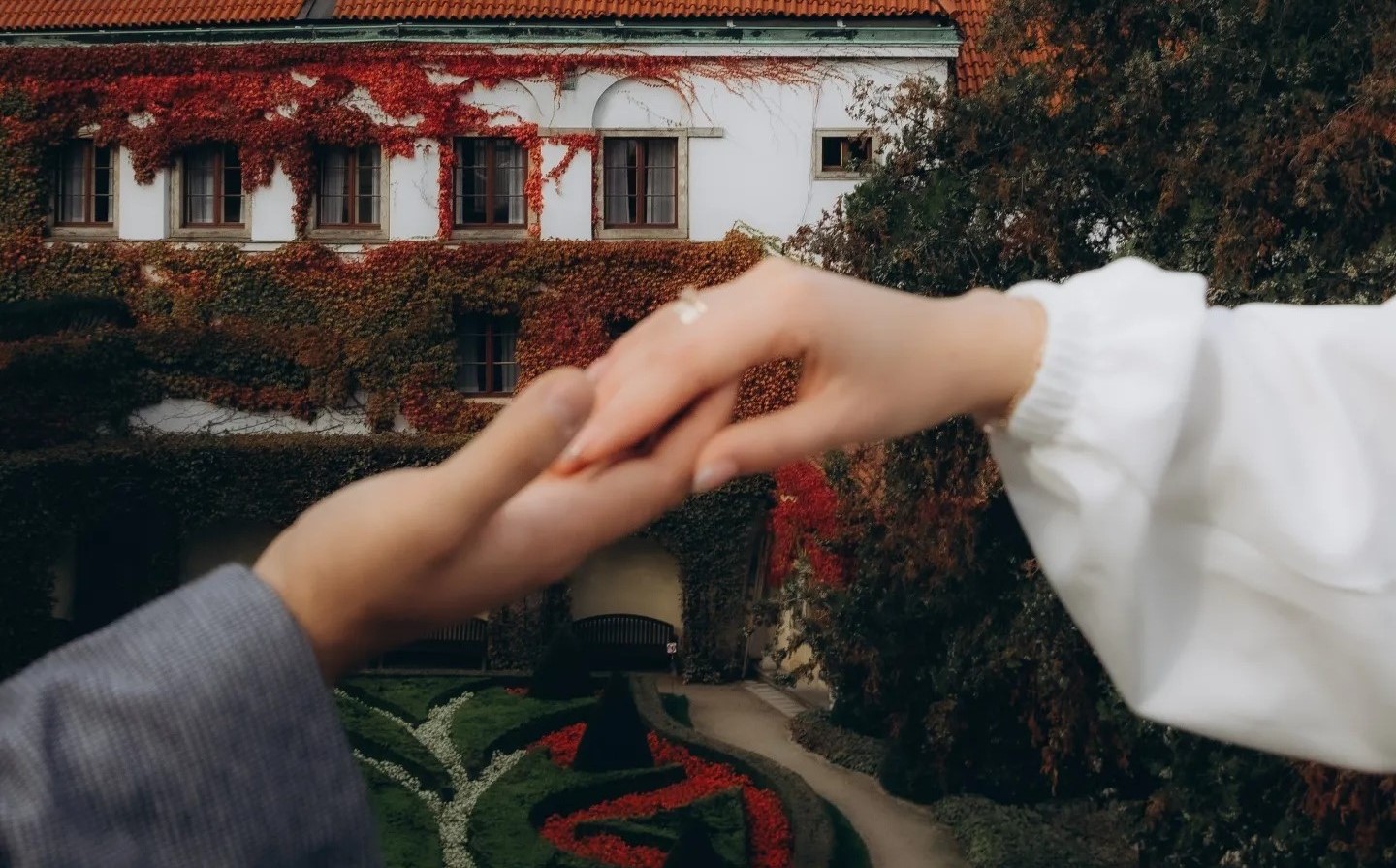 Couple's hands at wedding with old city background